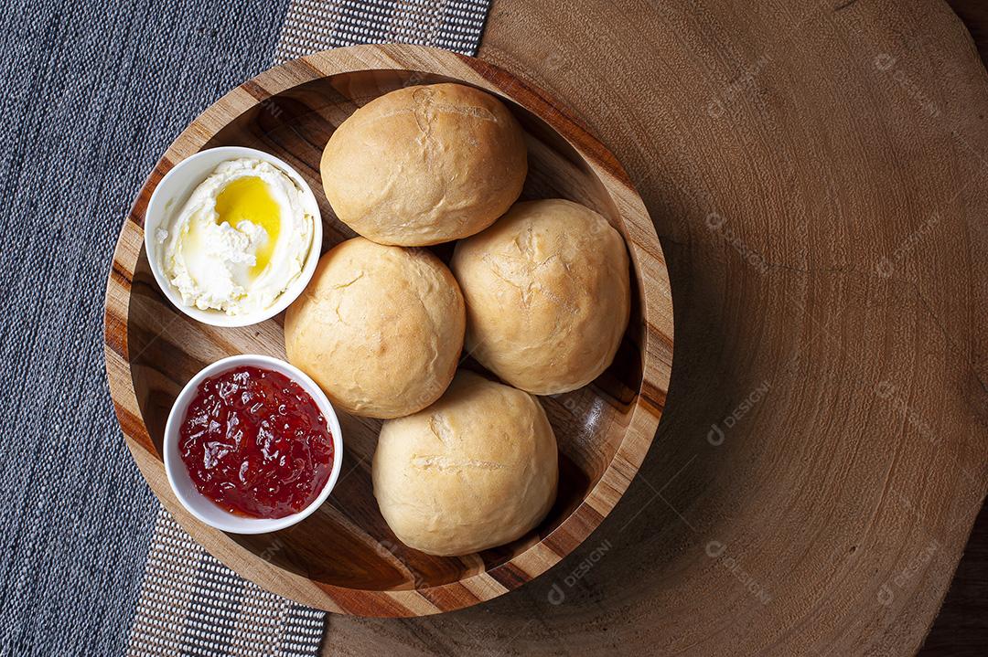 Pão caseiro em uma tigela de madeira acompanhado de coalhada e geleia JPG