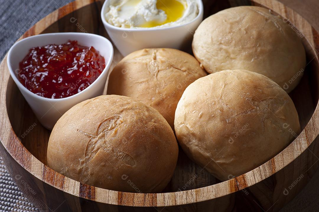 Pão caseiro em uma tigela de madeira acompanhado de coalhada e geleia JPG