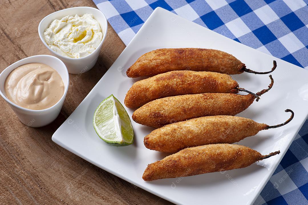 Pimentas recheadas com queijo, empanadas e fritas. Sagacidade acompanhada JPG