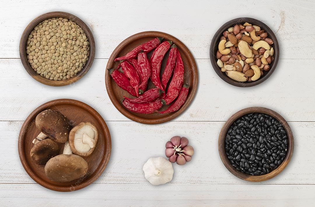 Feijão, nozes, pimenta, cogumelos e alho sobre a mesa de madeira