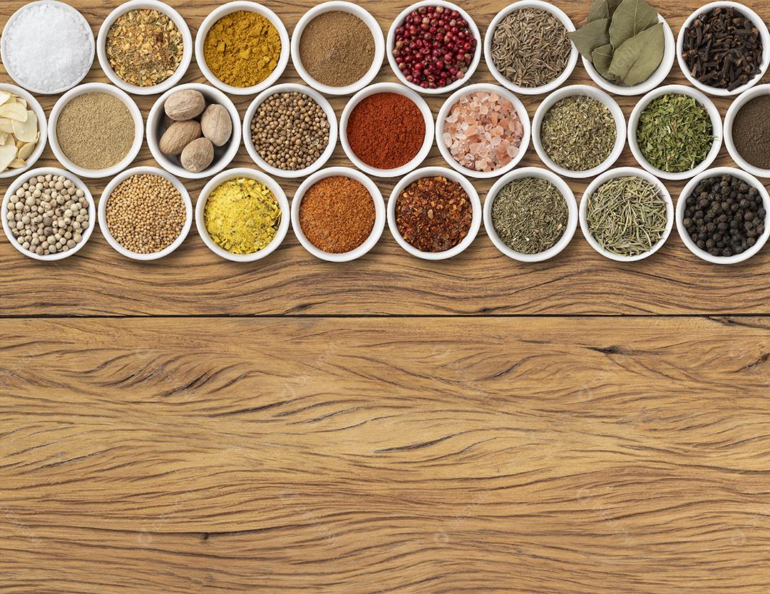 Temperos variados e ervas sobre mesa de madeira