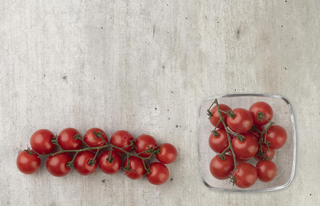 Tomate cereja em uma tigela isolada sobre fundo branco.