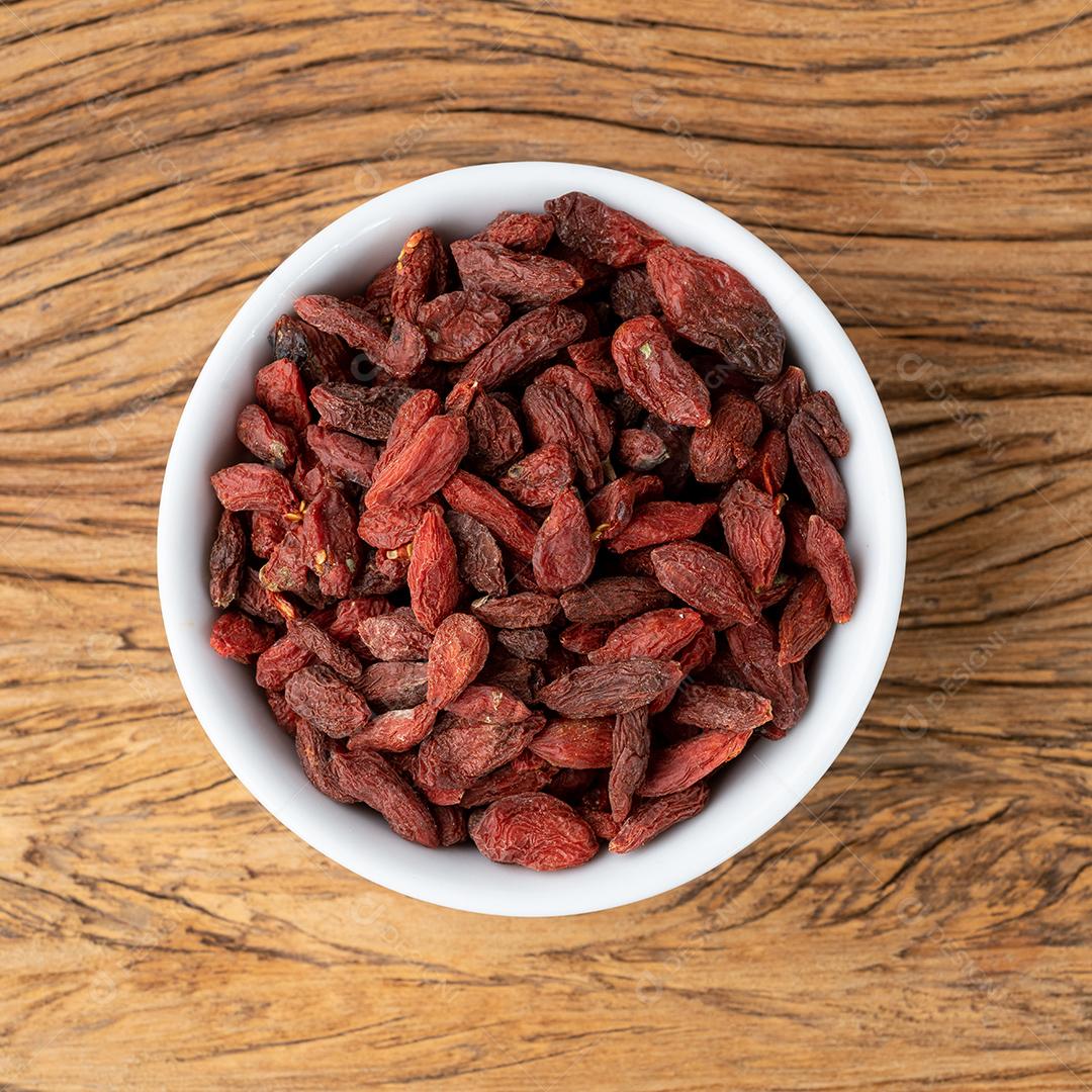 Goji berry em uma tigela sobre a mesa de madeira.