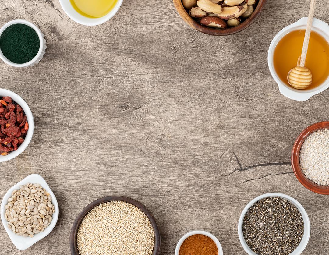 Superalimentos variados sobre fundo de madeira com espaço de cópia. Chia, quinoa