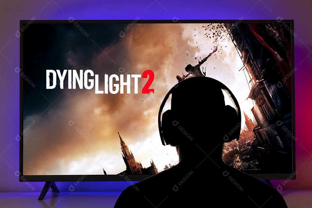 Homem com fones de ouvido jogando Dying Light 2 na TV