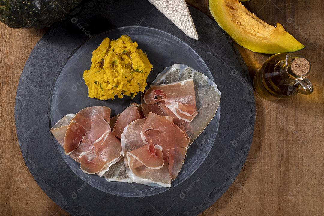 Presunto italiano crudo ou jamon com purê de abóbora Imagem JPG