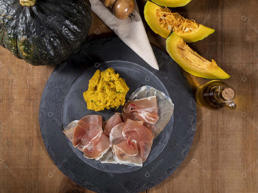 Presunto italiano crudo ou jamon com purê de abóbora Imagem JPG