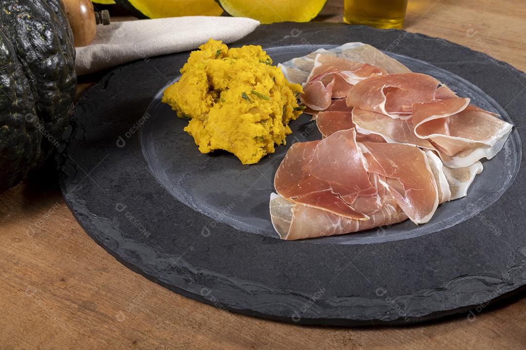Presunto italiano crudo ou jamon com purê de abóbora Imagem JPG