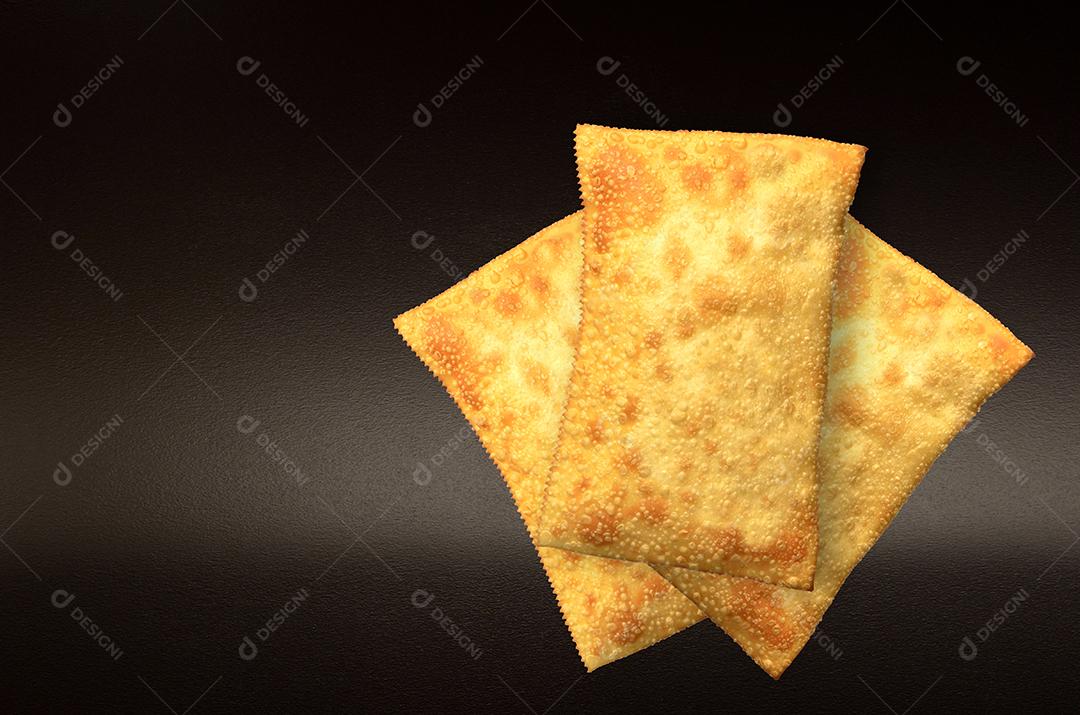 três pastéis em destaque em fundo preto