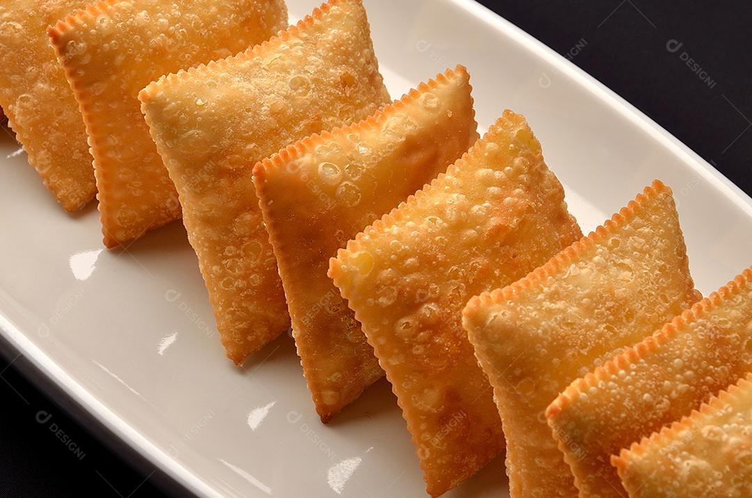 pastéis enfileirados servidos em prato branco