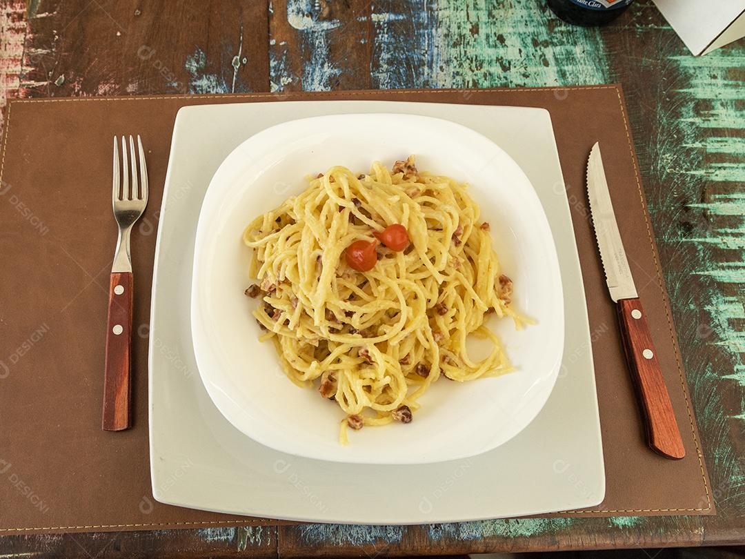Fotos Delicioso prato de espaguete carbonara na mesa de madeira