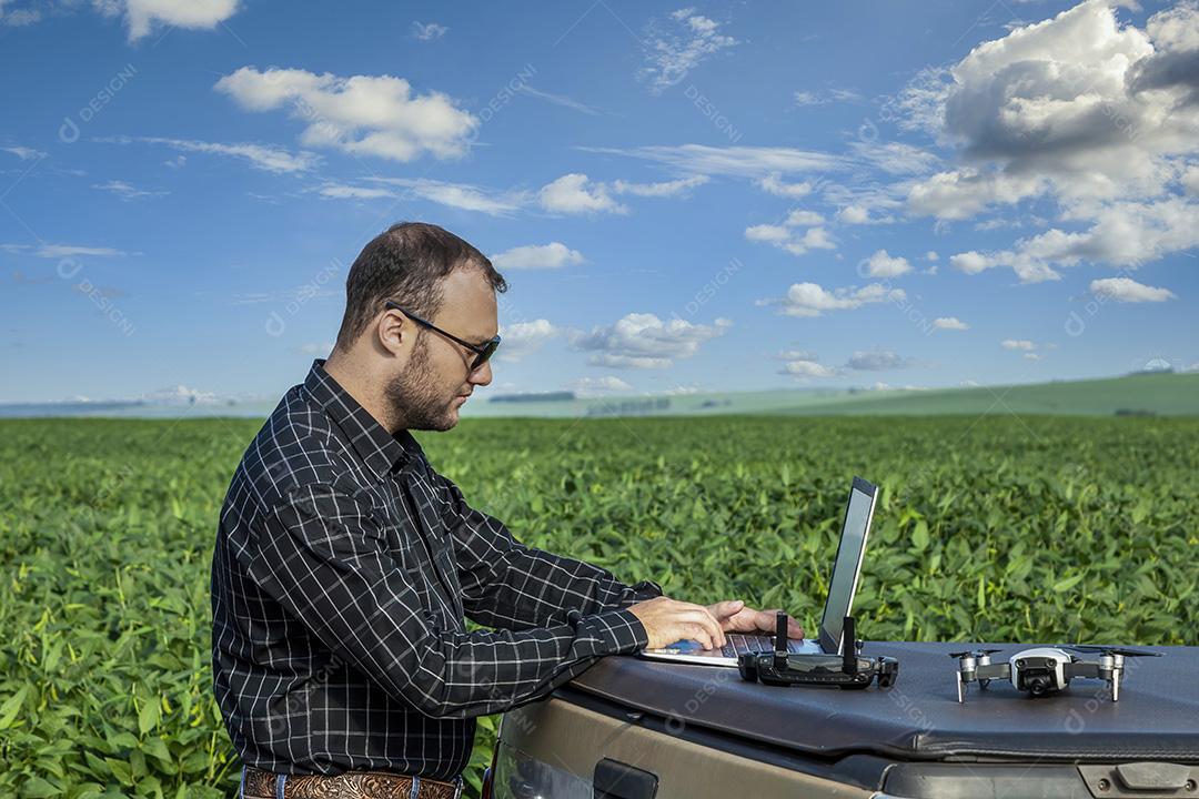 Jovem agricultor soja no campo de soja Imagem JPG