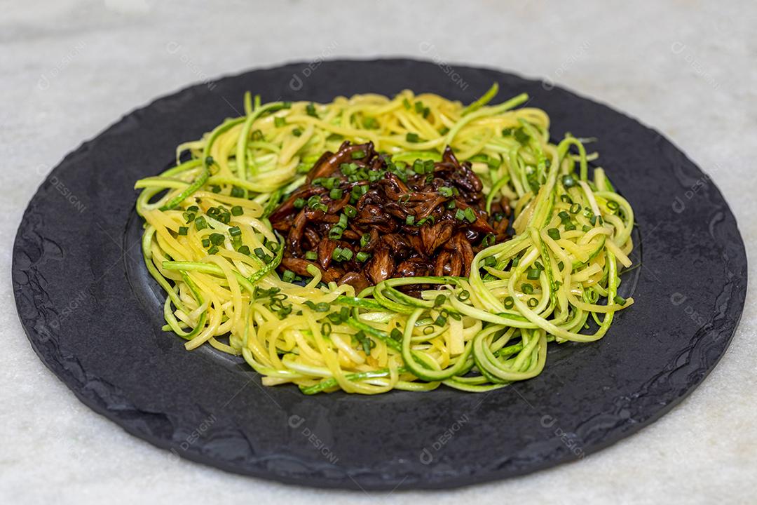 Espaguete de abobrinha com shimeji na placa de pedra preta Imagem JPG