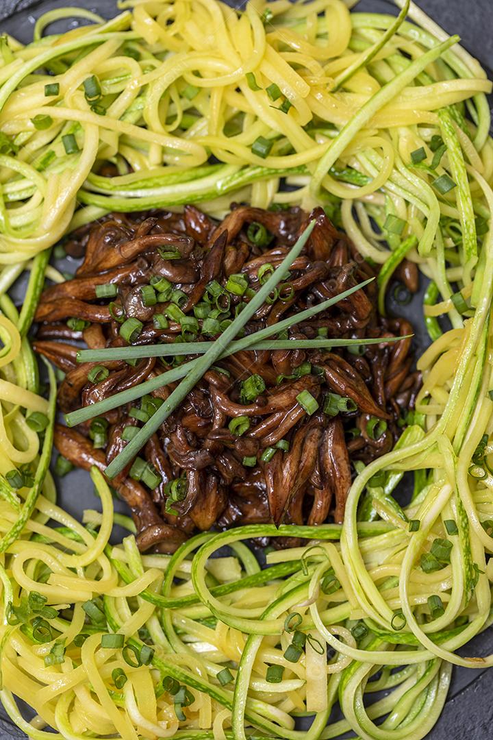 Espaguete de abobrinha com shimeji na placa de pedra preta Imagem JPG