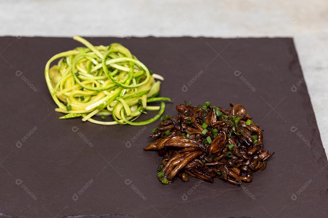 Espaguete de abobrinha com shimeji na placa de pedra preta Imagem JPG