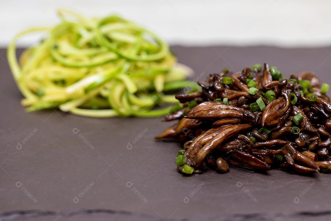 Espaguete de abobrinha com shimeji na placa de pedra preta Imagem JPG