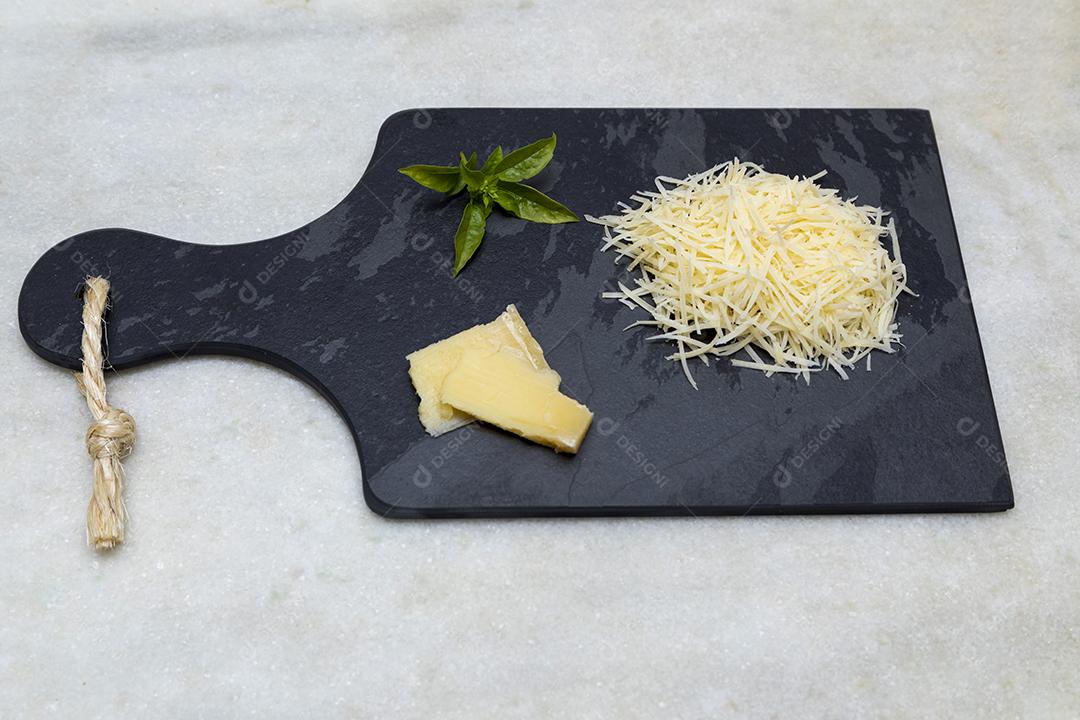 Fotos Queijo parmesão ralado na pedra preta com alho, cebola, pimenta e outras especiarias