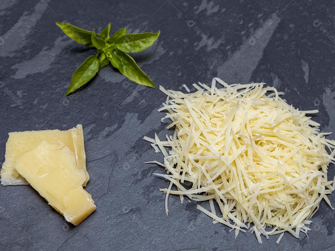Fotos Queijo parmesão ralado na pedra preta com alho, cebola, pimenta e outras especiarias