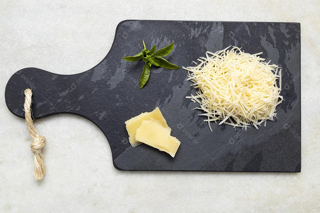 Fotos Queijo parmesão ralado na pedra preta com alho, cebola, pimenta e outras especiarias