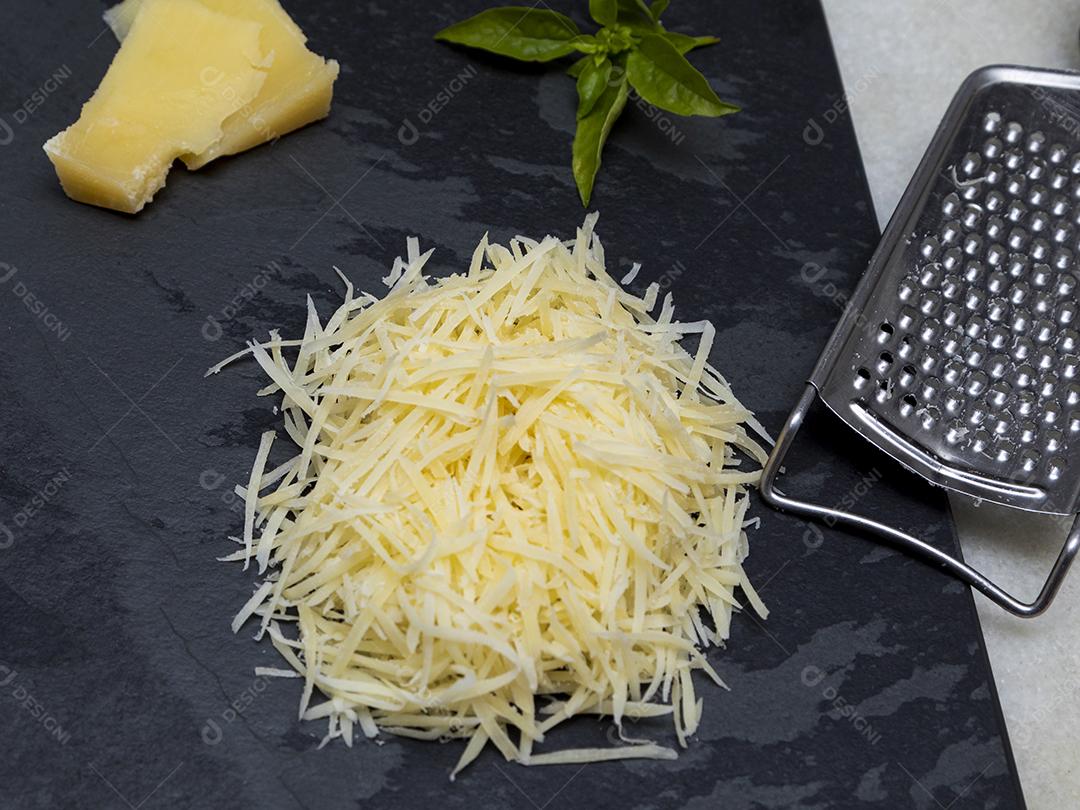 Fotos Queijo parmesão ralado na pedra preta com alho, cebola, pimenta e outras especiarias