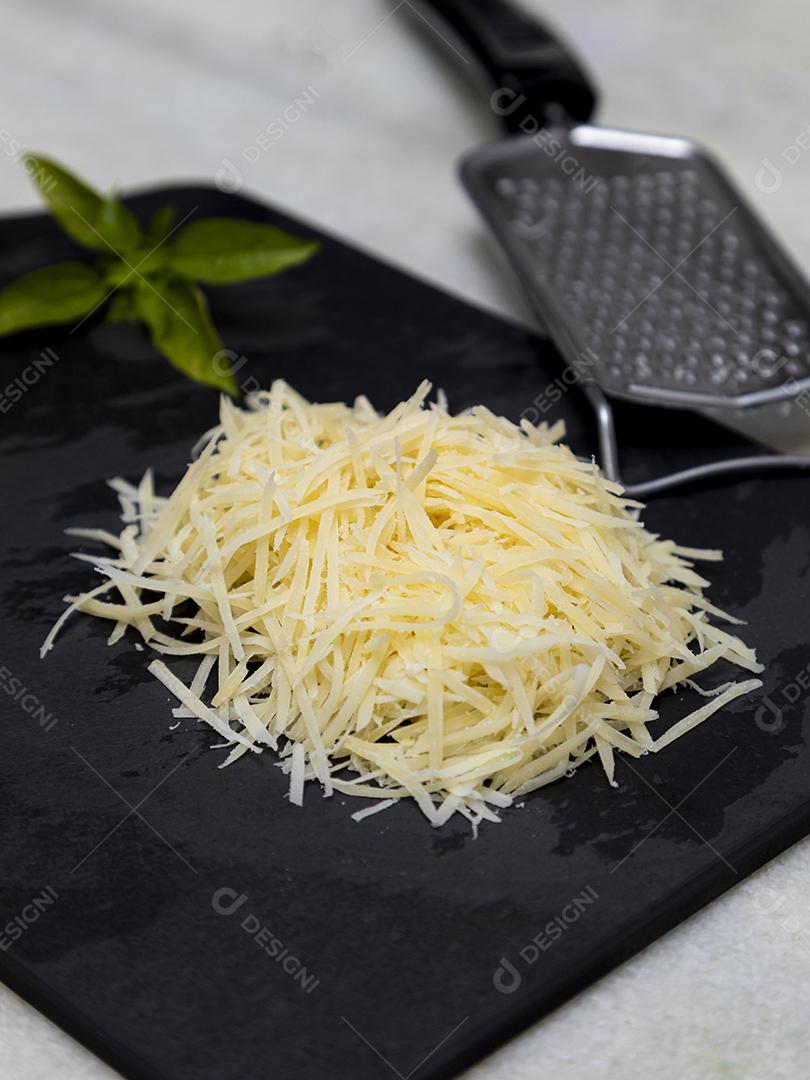 Fotos Queijo parmesão ralado na pedra preta com alho, cebola, pimenta e outras especiarias