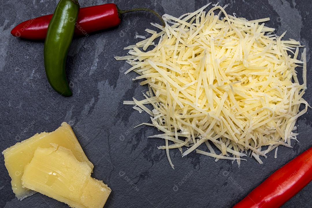 Fotos Queijo parmesão ralado na pedra preta com alho, cebola, pimenta e outras especiarias