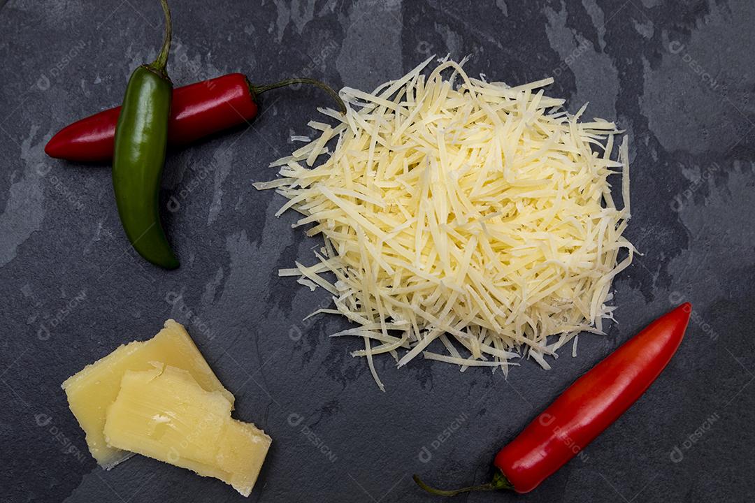 Fotos Queijo parmesão ralado na pedra preta com alho, cebola, pimenta e outras especiarias