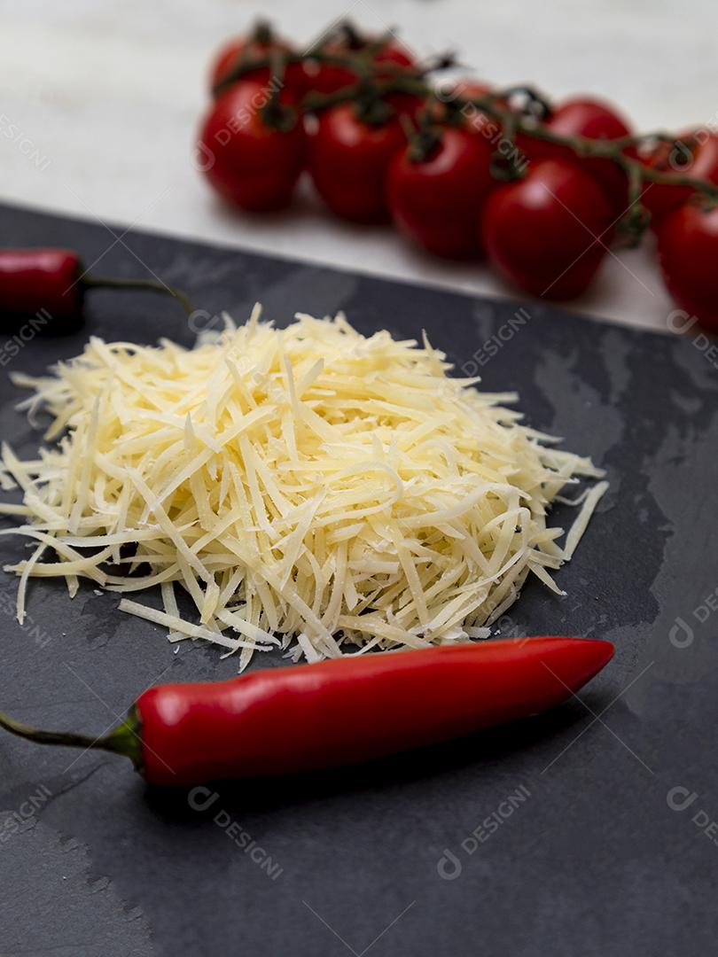 Fotos Queijo parmesão ralado na pedra preta com alho, cebola, pimenta e outras especiarias
