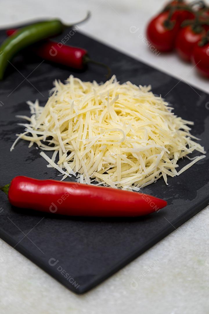 Fotos Queijo parmesão ralado na pedra preta com alho, cebola, pimenta e outras especiarias