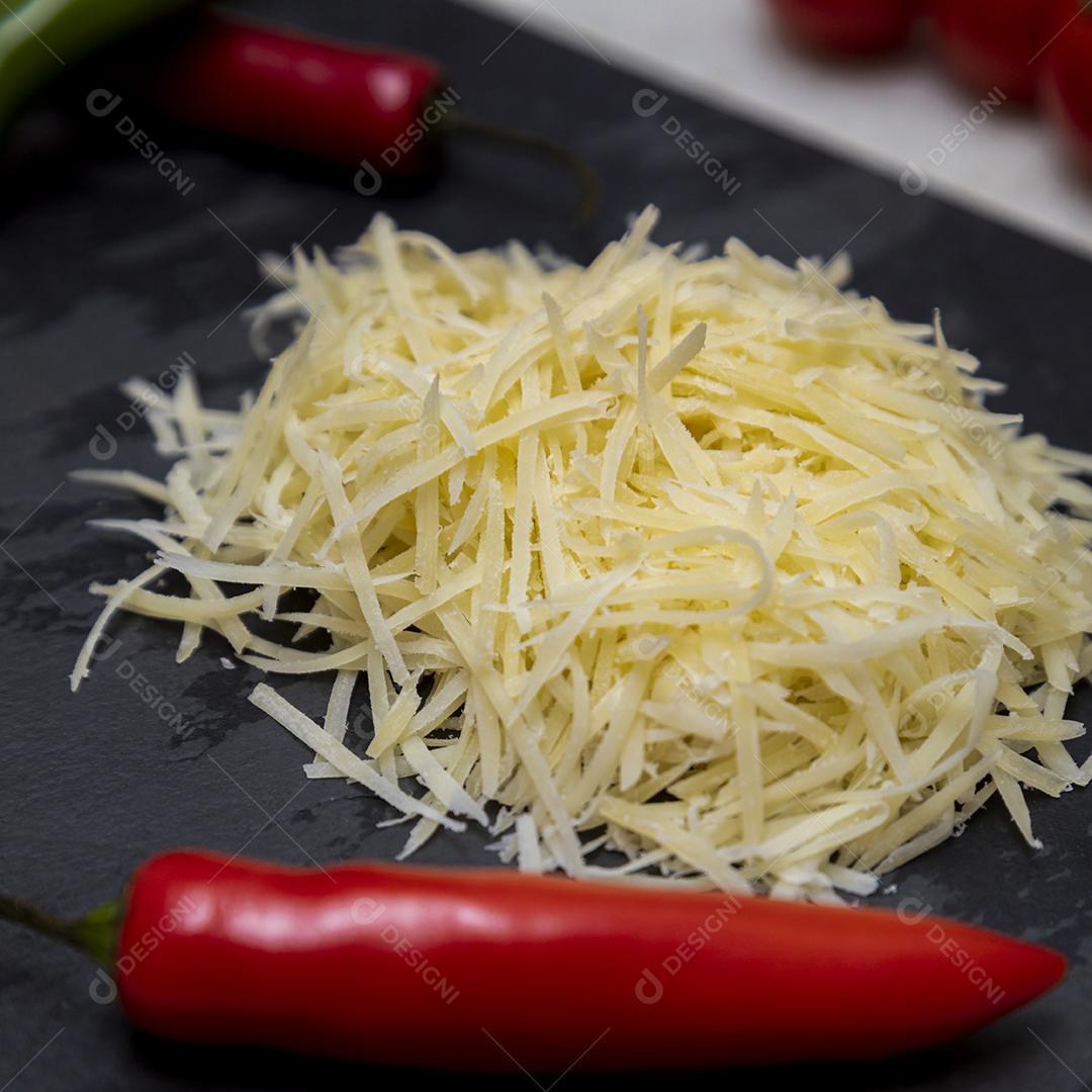 Fotos Queijo parmesão ralado na pedra preta com alho, cebola, pimenta e outras especiarias