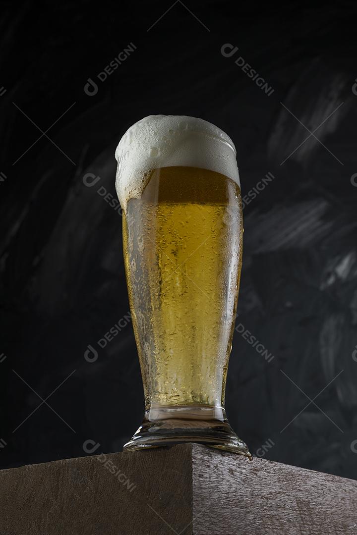 Cerveja gelada. Copo cheio de cerveja. Copo transbordante de espuma de cerveja