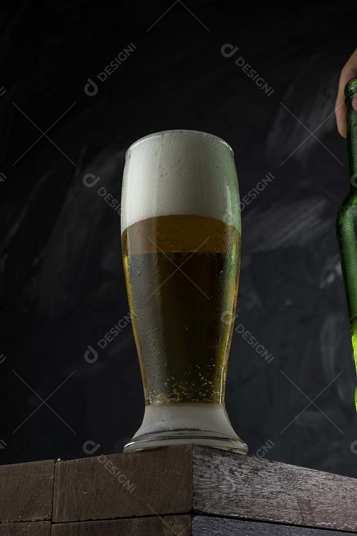 Cerveja gelada. Copo cheio de cerveja. Copo transbordante de espuma de cerveja