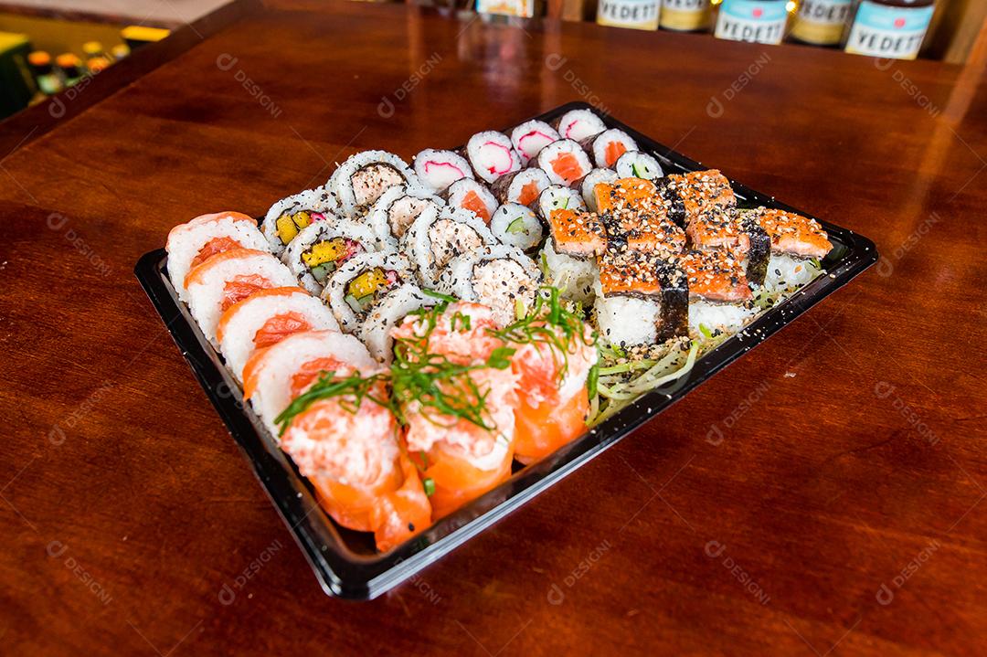 Comida japonesa. Sushi Kome. Salmão, sushi em alga, arroz enroladinho, temperos