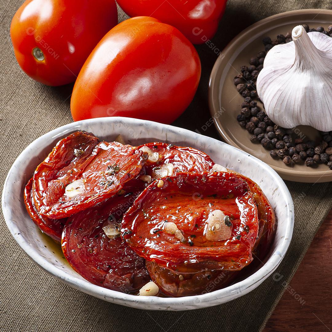 Tomates secos ao sol em uma tigela com azeite JPG