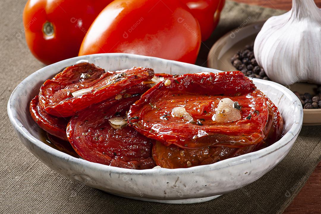 Tomates secos ao sol em uma tigela com azeite JPG