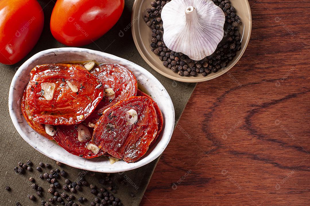 Tomates secos ao sol em uma tigela com azeite JPG