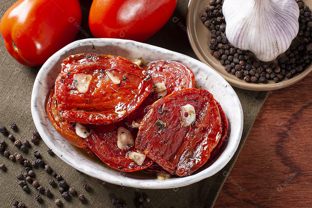 Tomates secos ao sol em uma tigela com azeite JPG
