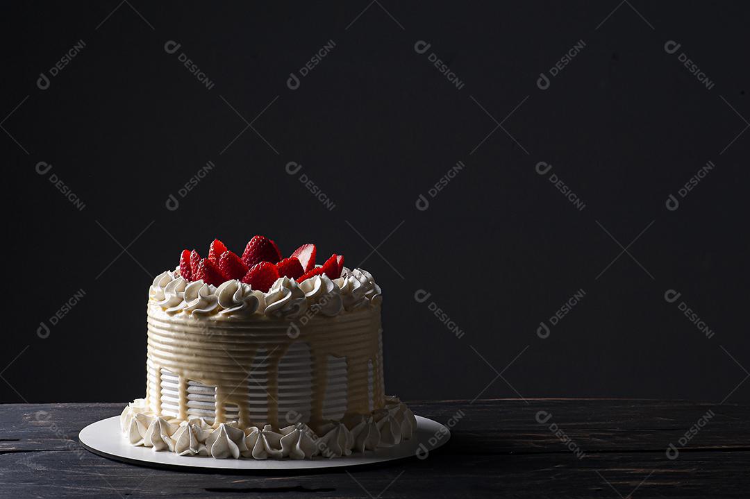 Bolo de aniversário lindo coberto com chantilly e palha fresca JPG