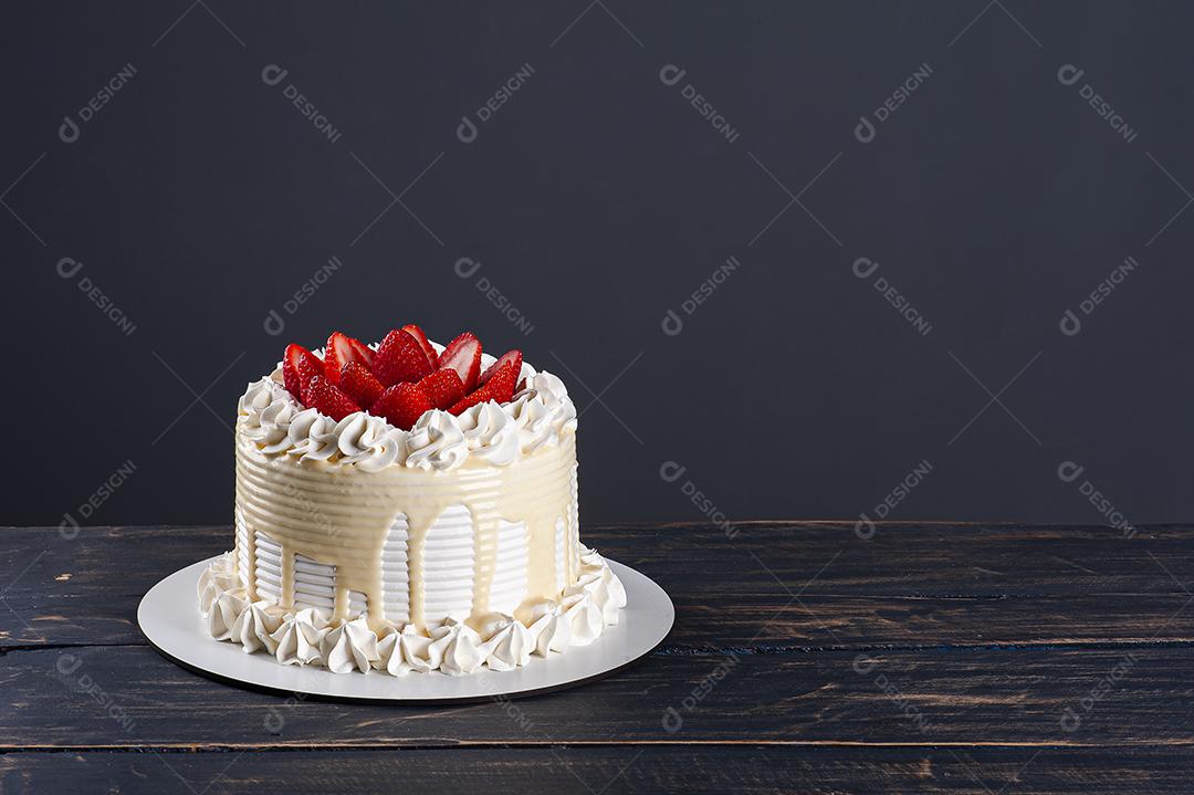 Bolo de aniversário lindo coberto com chantilly e palha fresca JPG