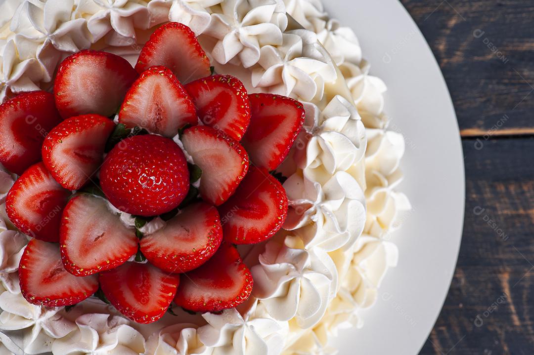 Bolo de aniversário lindo coberto com chantilly e palha fresca JPG