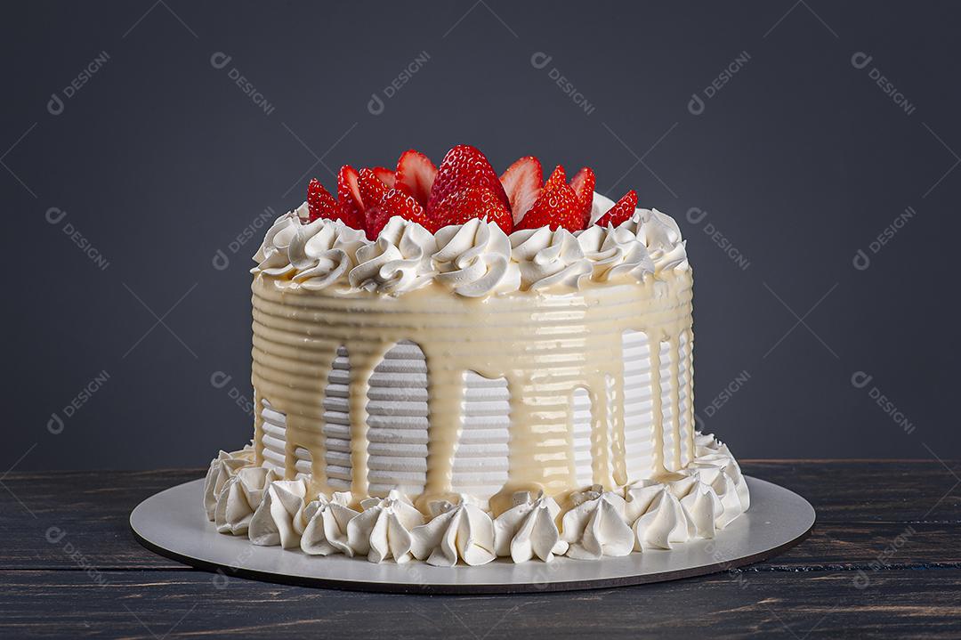 Bolo de aniversário lindo coberto com chantilly e palha fresca JPG