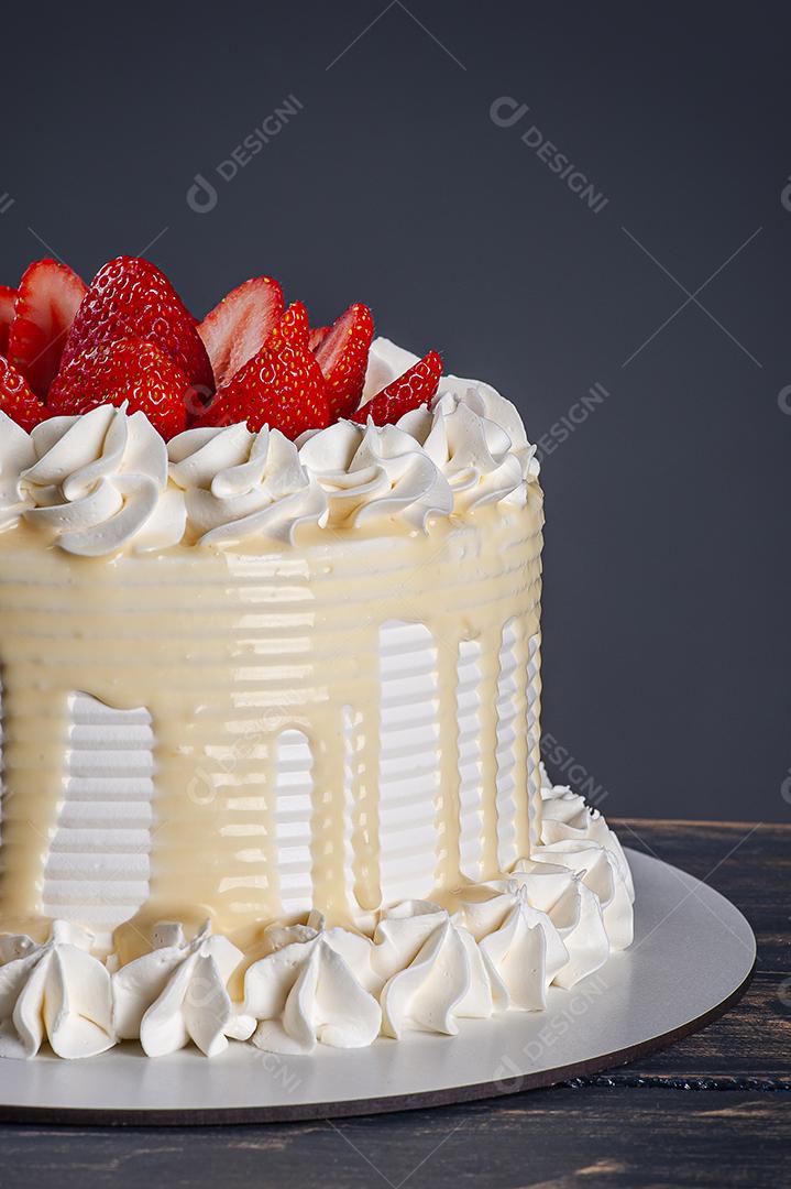 Bolo de aniversário lindo coberto com chantilly e palha fresca JPG