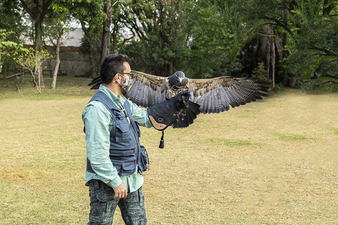 Homem segurando uma aguia passaro aves