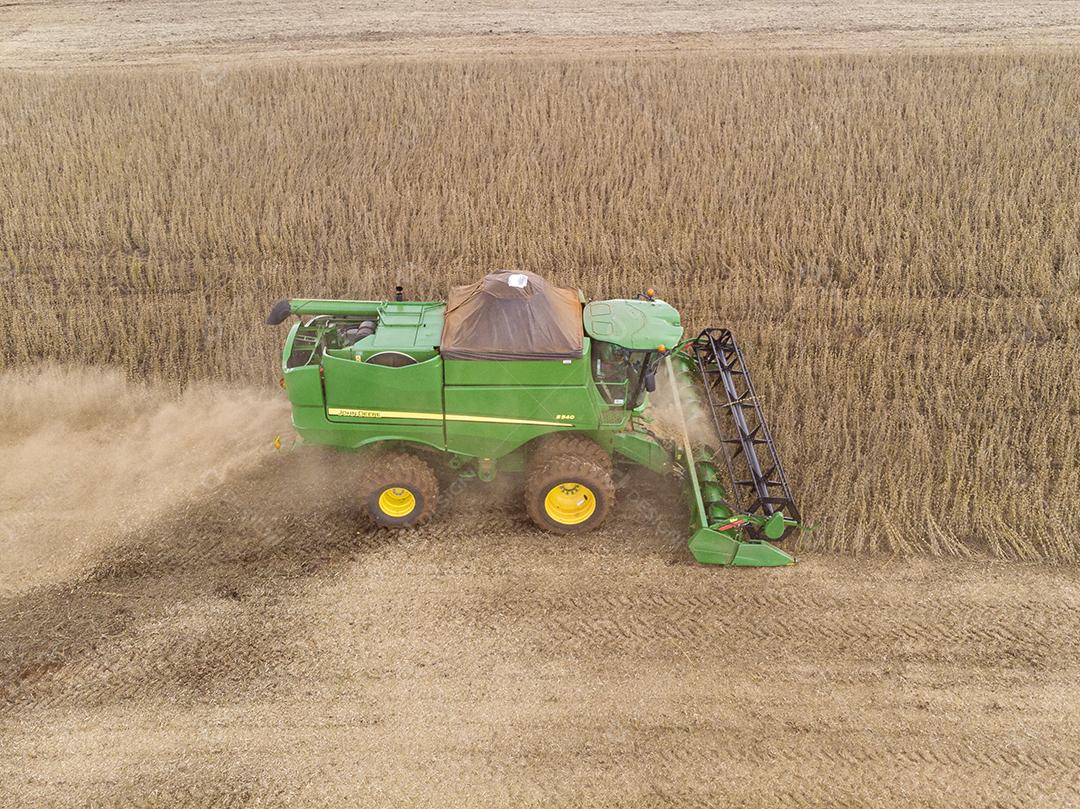 Trator agrícola colhendo soja no campo Imagem JPG
