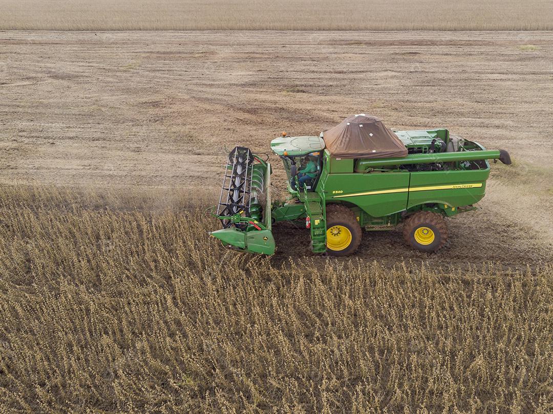 Trator agrícola colhendo soja no campo Imagem JPG
