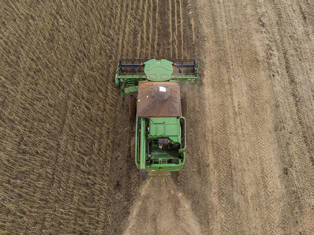 Trator agrícola colhendo soja no campo Imagem JPG