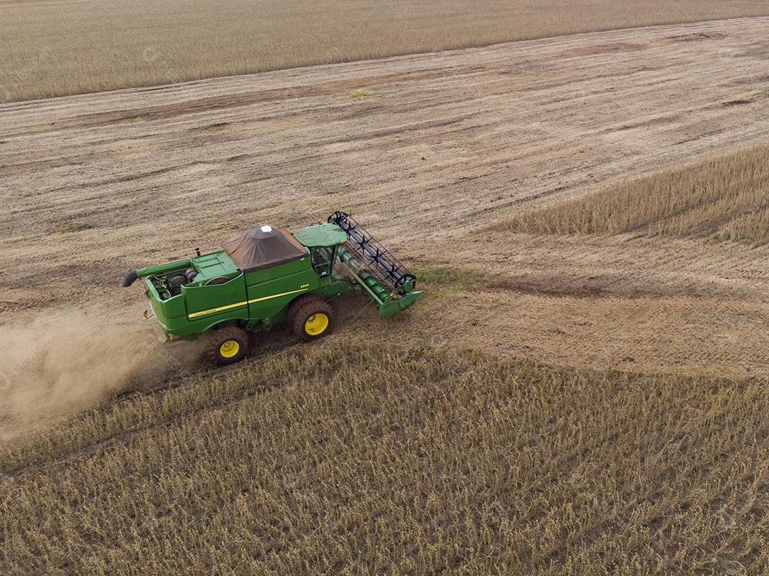 Trator agrícola colhendo soja no campo Imagem JPG