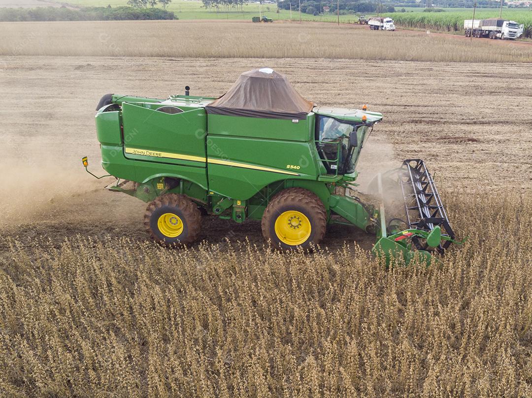 Trator agrícola colhendo soja no campo Imagem JPG