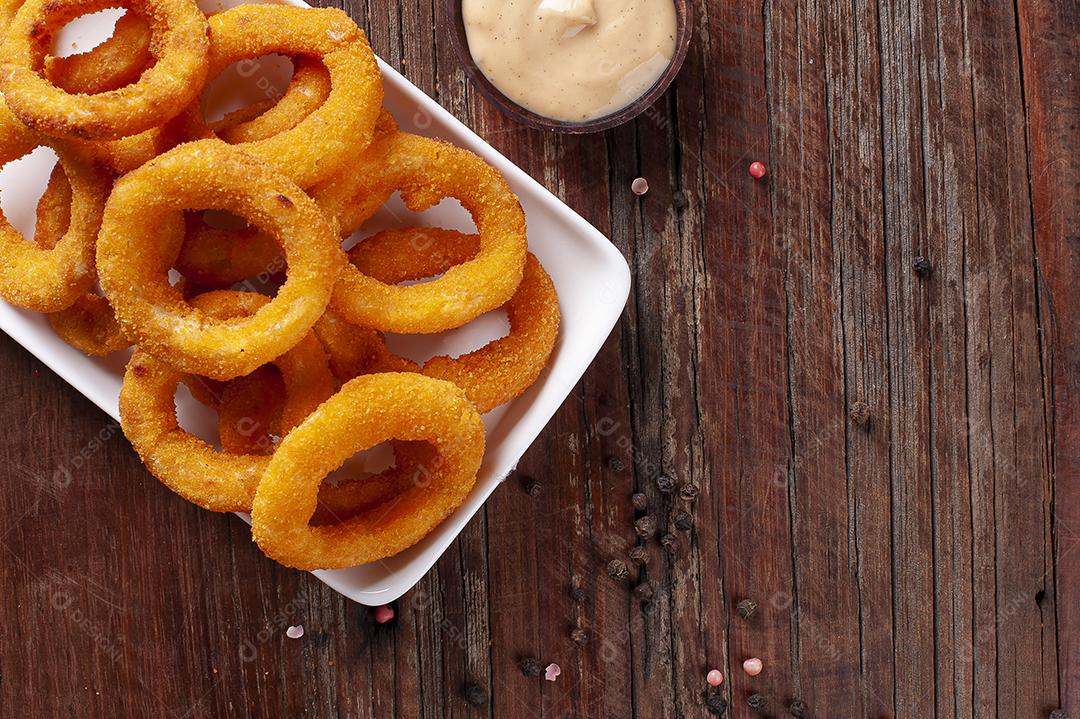 Deliciosos anéis de cebola fritos crocantes caseiros com molho picante