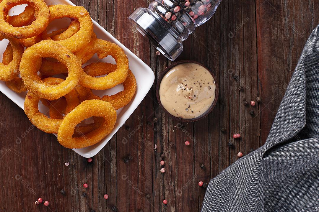 Deliciosos anéis de cebola fritos crocantes caseiros com molho picante